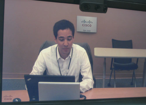 Системный инженер компании Cisco Эльер Хакимов на экране плазменной панели во время телемоста с Сан-Хосе